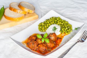 Meatballs in tomato sauce with sauteed peas